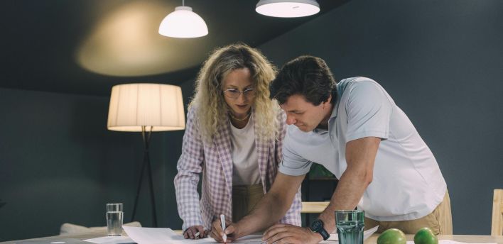 Two professionals collaborating over a project in a modern office setting.